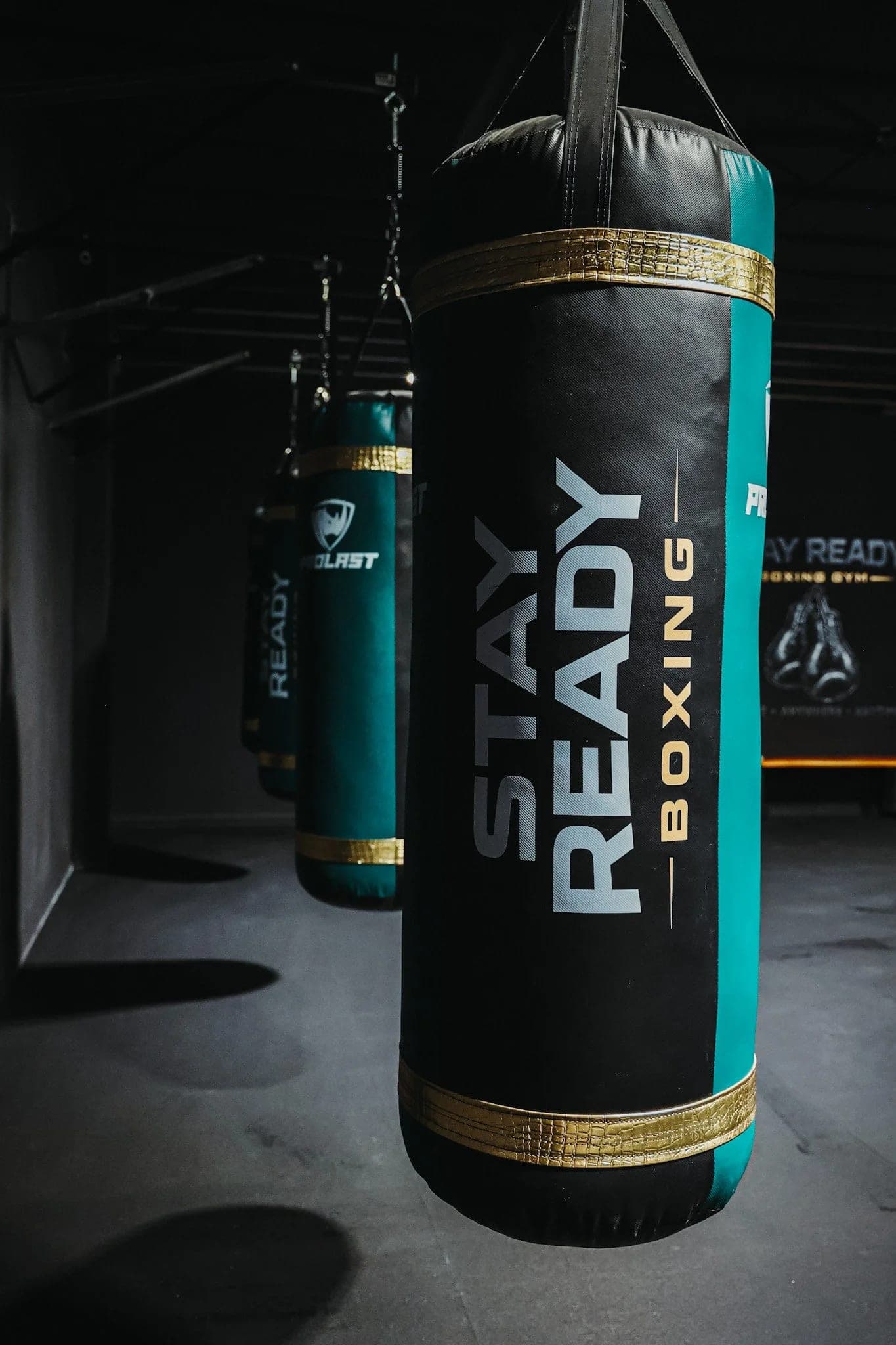 A Stay Ready Boxing Gym heavy bag in the foreground, the gym logo visible on the wall behind it.